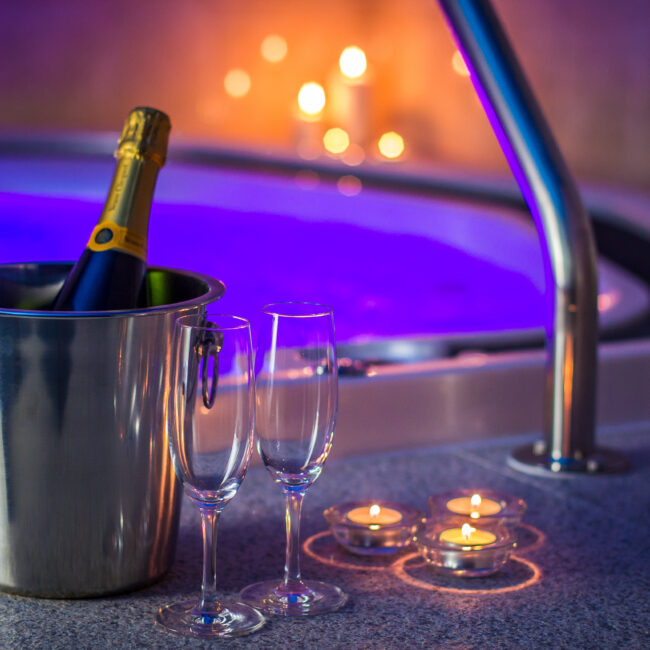 A bottle of champagne in the bucket and candles near the hot tube.A truly romantic atmosphere.